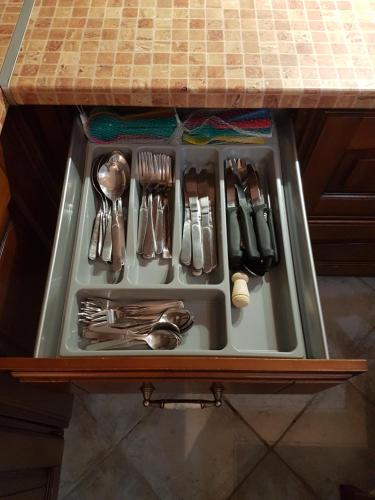 a drawer with utensils and utensils at HoneyHouse in Kádhion