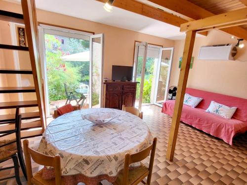 un salon avec une table et un canapé dans l'établissement Maison T3 climatisée avec jardin, garage privatif et terrasse à 900 m des plages - Animaux admis - FR-1-316-272, à Six-Fours-les-Plages