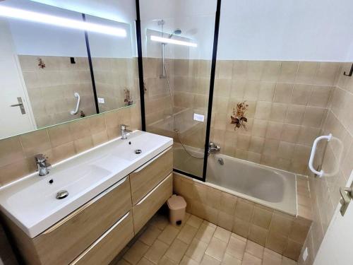 une salle de bain avec une baignoire, un lavabo et une douche dans l'établissement Maison T3 climatisée avec jardin, garage privatif et terrasse à 900 m des plages - Animaux admis - FR-1-316-272, à Six-Fours-les-Plages