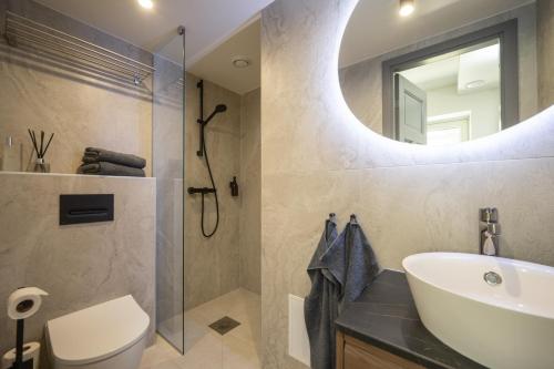 a bathroom with a sink toilet and a mirror at Pärnu Pearl Residences in Pärnu