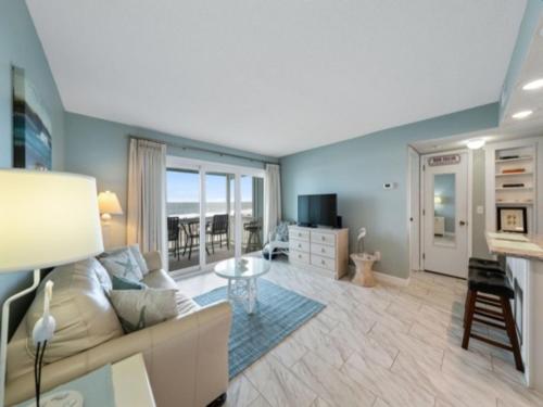 a living room with a couch and a table at Beach Bliss condo in Carolina Beach