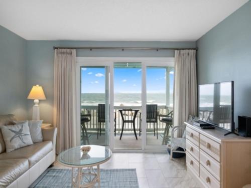 a living room with a couch and a view of the ocean at Beach Bliss condo in Carolina Beach