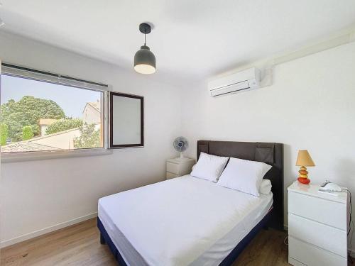 une chambre avec un lit blanc et une fenêtre dans l'établissement Élégant T3 Climatisé à Saint-Cyr-sur-Mer, Proche Plage des Lecques, Terrasse et Parking - FR-1-770-10, à Saint-Cyr-sur-Mer