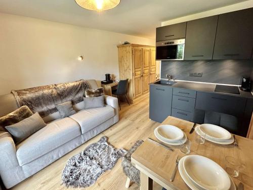 un salon avec un canapé et une table dans l'établissement Charmant studio avec balcon exposé sud, casier à skis et parking, proche des pistes à Demi-Quartier - FR-1-597-175, à Demi-Quartier