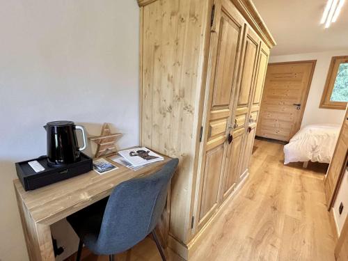 Cette chambre dispose d'un bureau en bois et d'une cafetière. dans l'établissement Charmant studio avec balcon exposé sud, casier à skis et parking, proche des pistes à Demi-Quartier - FR-1-597-175, à Demi-Quartier