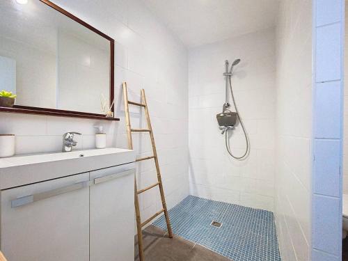 La salle de bains est pourvue d'une douche et d'une échelle à côté d'un lavabo. dans l'établissement Havre de paix entre nature et mer, T2 refait à neuf, climatisé, idéal pour 4! - FR-1-770-18, à Saint-Cyr-sur-Mer