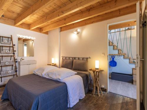 une chambre avec un lit dans une pièce avec un escalier dans l'établissement Charmante maison de village à Luz-Saint-Sauveur, 4 pers., proche pistes, poêle à bois, parking. - FR-1-402-141, à Luz-Saint-Sauveur