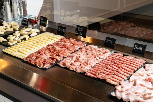 a buffet with many different types of meats and cheese at Araba Fenice Hotel in Iseo