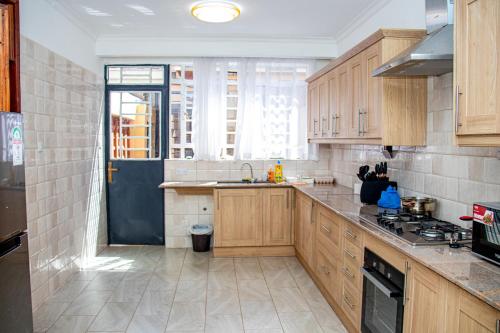 a large kitchen with wooden cabinets and a sink at Kathy's Serene Suites in Nairobi