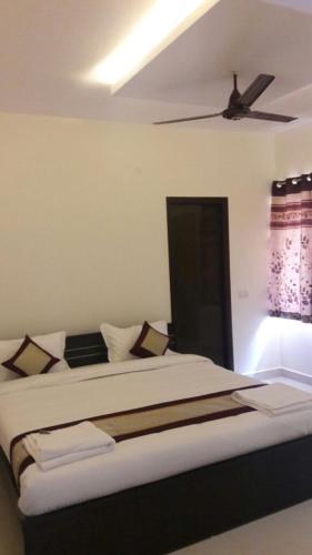 a bedroom with a bed with a ceiling fan at 7 Hills Service Apartments in Chennai