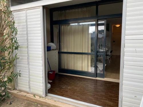 a sliding glass door of a house with a patio at Appartamento in residence con piscina in Marina di Bibbona
