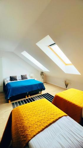 a bedroom with two beds and a skylight at Apartamenty Marco Polo in Dziwnówek