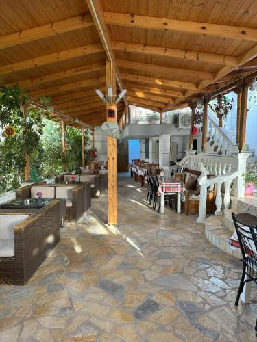 an outdoor patio with a wooden ceiling and tables and chairs at Garden Villa Veli in Ksamil
