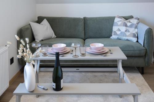 a living room with a green couch and a white coffee table at Pärnu Pearl Residences in Pärnu
