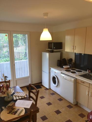 une cuisine avec lave-linge, sèche-linge et une table dans l'établissement Au fil du Chassezac #Miel, à Chambonas