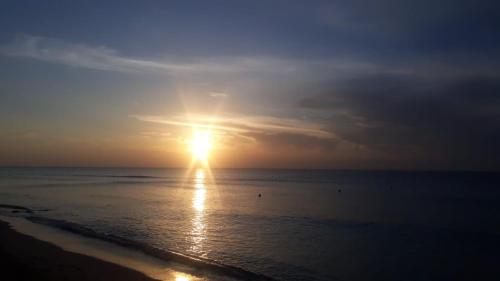un coucher de soleil sur l'océan avec le soleil dans le ciel dans l'établissement Studio 200m à pied de la mer, à La Rochelle