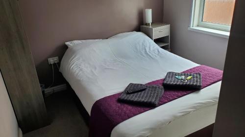 a bedroom with a bed with two towels on it at Leecliff Guest House in Blackpool