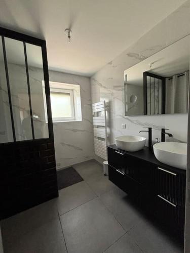 une salle de bain avec deux lavabos et un grand miroir dans l'établissement Gîte Le Clos des Hirondelles en Limousin, à Saint-Victurnien