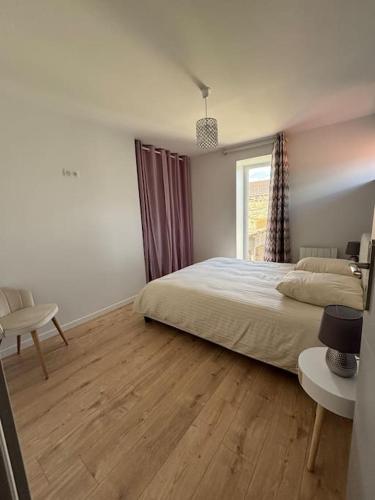 une chambre avec un lit, un bureau et une fenêtre dans l'établissement Gîte Le Clos des Hirondelles en Limousin, à Saint-Victurnien