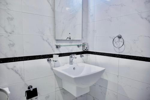 a white bathroom with a sink and a mirror at Sea Villa Chalets in An Nāmī