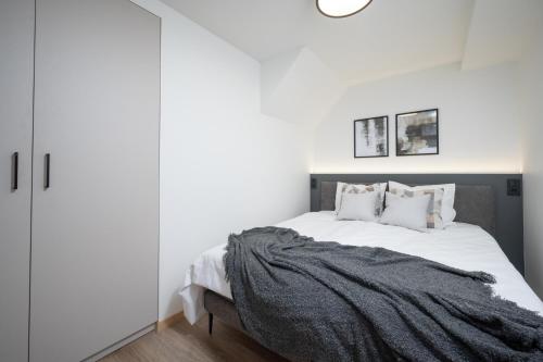 a bedroom with a large bed with white walls at Pärnu Pearl Residences in Pärnu
