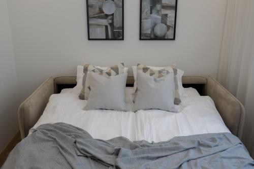 a bed with white sheets and pillows on it at Pärnu Pearl Residences in Pärnu