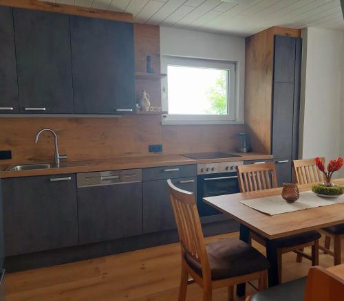 a kitchen with a table and a sink and a table and chairs at Ferienwohnung Leonhardbauer in Kleinfeistritz