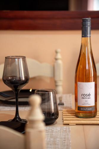 a bottle of wine next to a glass on a table at Greg's House in Vitalades