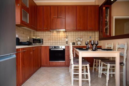 a kitchen with wooden cabinets and a table with stools at Greg's House in Vitalades