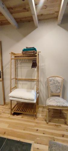 une chambre avec une chaise, une étagère et une chaise dans l'établissement Le Mazel, à Saint-Agrève