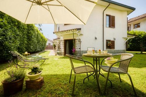 a patio with a table and chairs and an umbrella at The Peaceful Apartament Close to Milan in Trezzano sul Naviglio