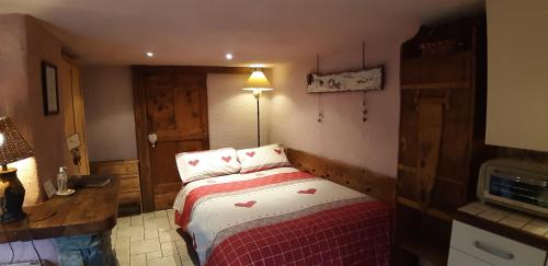 a bedroom with a bed with a red and white blanket at CleMaison Antica Dimora Apartments CIR VDA GIGNOD 0013 in Gignod
