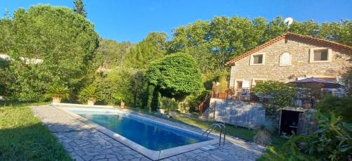 une piscine dans une cour à côté d'une maison dans l'établissement l'Oulibo, à Villeneuve-les-Corbières