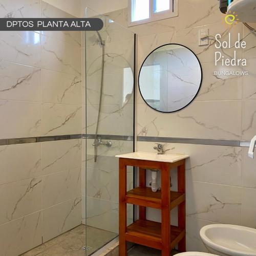 a bathroom with a shower with a sink and a mirror at Bungalows Sol de Piedra in Federación