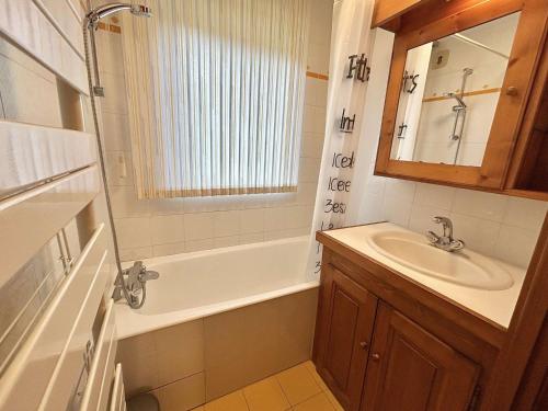 une salle de bain avec une baignoire, un lavabo et un miroir dans l'établissement Appartement cosy 2P+cabine, 6 couchages, proche télécabine Jaillet et centre, balcon Sud, garage privé - FR-1-597-176, à Megève