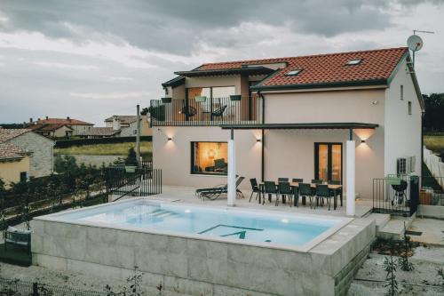 a villa with a swimming pool in front of a house at Casa Vitale in Tinjan