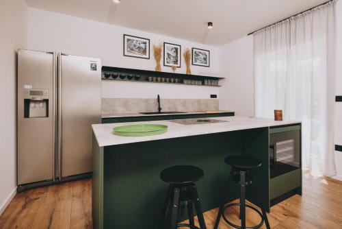 a kitchen with a green island with a refrigerator at Casa Vitale in Tinjan