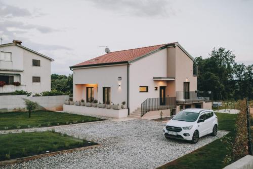 a white car parked in front of a house at Casa Vitale in Tinjan