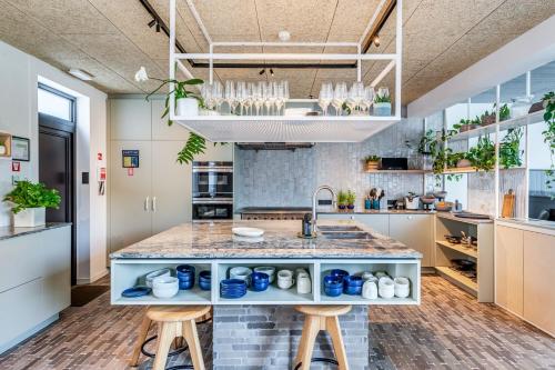 a kitchen with a sink and a counter with stools at Gare 55 in Evergem