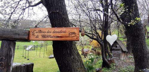 a sign hanging on a tree in a park at CleMaison Antica Dimora Apartments CIR VDA GIGNOD 0013 in Gignod