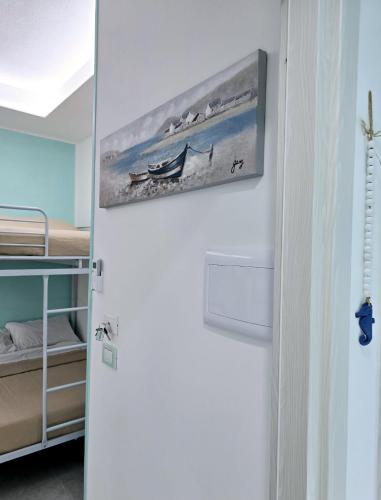 a white refrigerator in a room with a painting on the wall at Aquamarina Rooms in Porto Cesareo