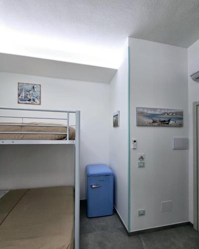 a bedroom with a bunk bed and a blue trash can at Aquamarina Rooms in Porto Cesareo