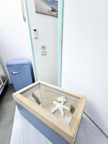 a wooden box with an anchor and an ocean at Aquamarina Rooms in Porto Cesareo