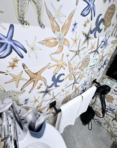 a bathroom with a toilet with a wall covered in stars at Aquamarina Rooms in Porto Cesareo