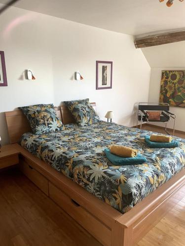 une chambre avec un grand lit avec des oreillers dessus dans l'établissement La maison champenoise, à Neuvy