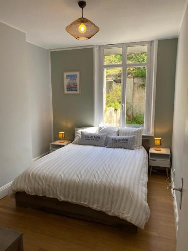 une chambre avec un lit avec des draps blancs et une fenêtre dans l'établissement cutty shark, à Boulogne-sur-Mer