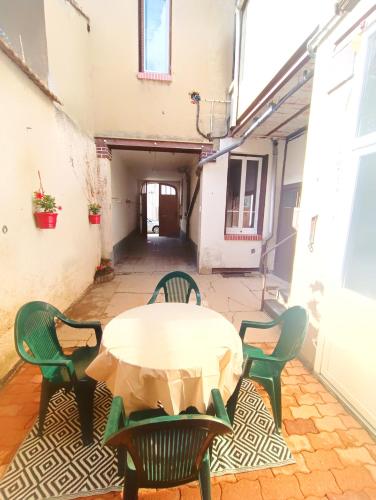 une cour avec une table et des chaises dans l'établissement Le romalie, à Vichy