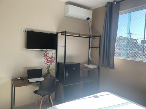 a room with a desk with a laptop and a window at Pousada EAS Suítes Internacionais 10min GRU in Guarulhos