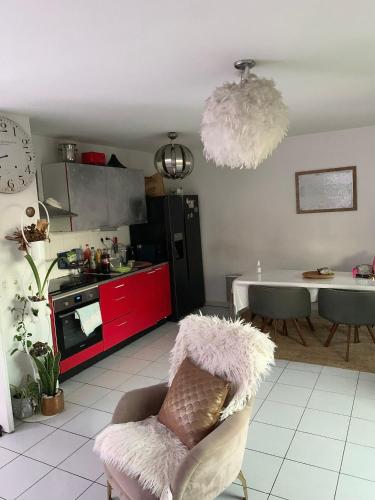 Il comprend une cuisine avec des placards rouges et du carrelage blanc. dans l'établissement GrandT3 terrasse vue sur vélodrome, à Marseille