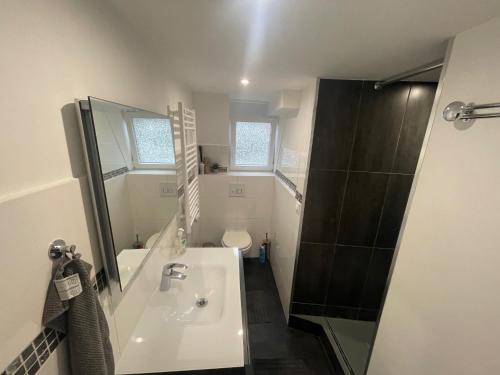 une salle de bain blanche avec un lavabo et une douche dans l'établissement Studio en plein coeur de Trouville, à Trouville-sur-Mer